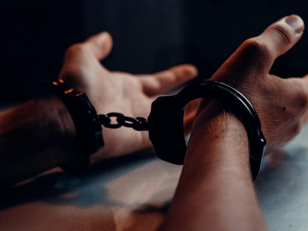 Hands in handcuffs dark image