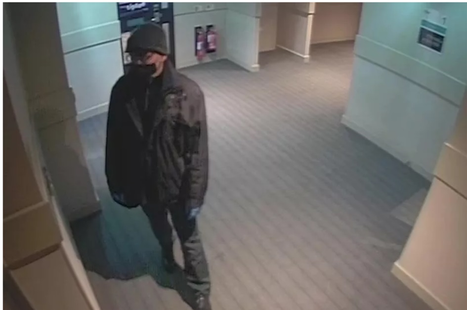 Thomas Kwan CCTV photo. He is in hallway of premier inn dressed in all black including hat and black face mask.