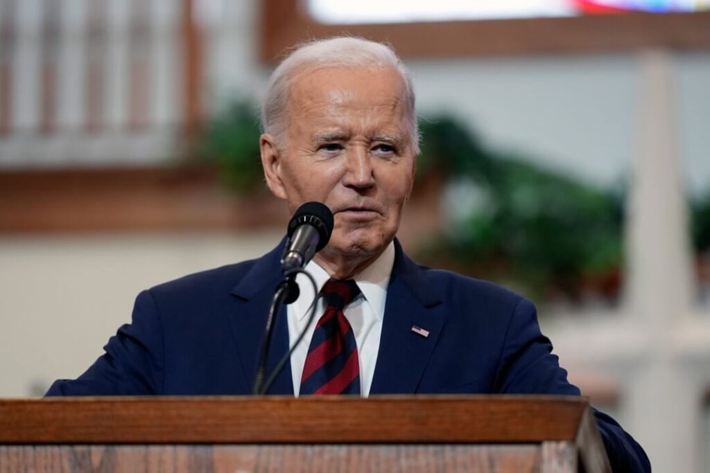 Former President Joe Biden standing at a lectern